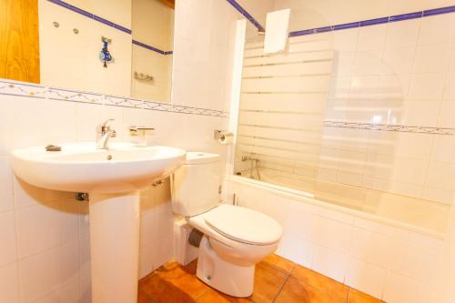 a bathroom with a toilet and a sink and a shower at El Bulin de Paredes in Paredes de Buitrago