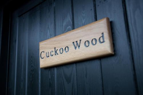 a wooden sign on a wall with the word cuckoo wood at The Plough Inn in Stalisfield