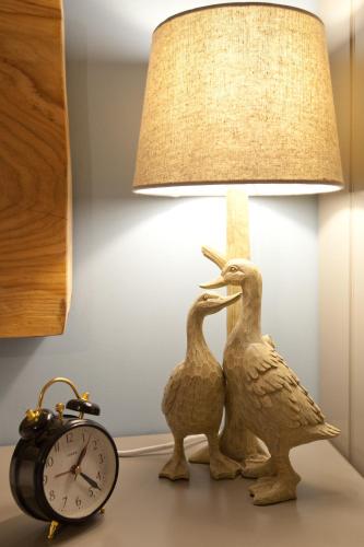 two birds statue next to a lamp and an alarm clock at The Plough Inn in Stalisfield