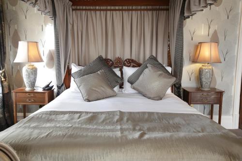 a bedroom with a large bed with pillows and two lamps at Rothley Court Hotel by Greene King Inns in Rothley