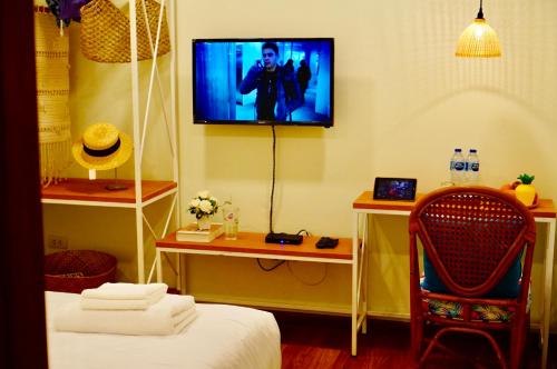 a room with a tv and a bed and a chair at Summer Stay Sattahip in Sattahip