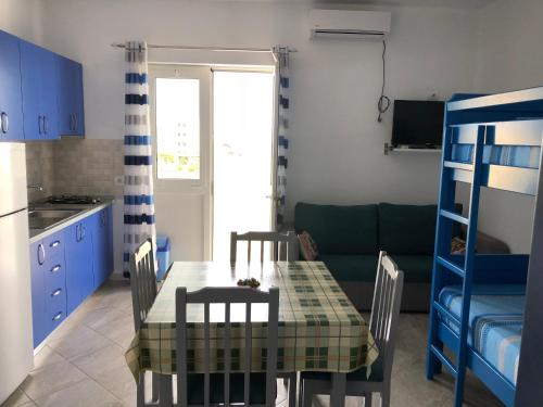 a kitchen and dining room with a table and chairs at Doci Seven Hotel in Velipojë