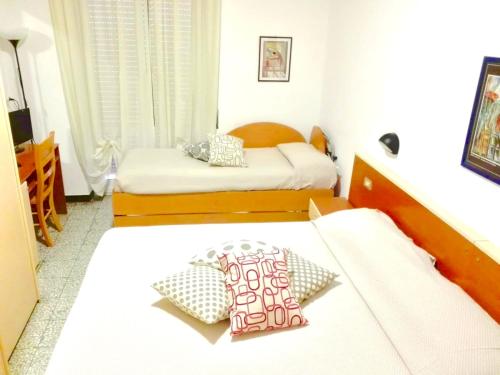 ピエトラ・リーグレにあるAlbergo Albatrosのベッド2台が備わる小さな部屋のベッド2台