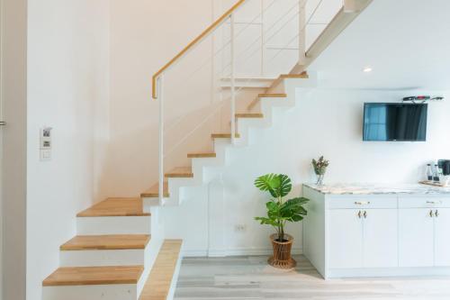 a white staircase in a home with a potted plant at White Ivory Bed And Breakfast in Bangkok
