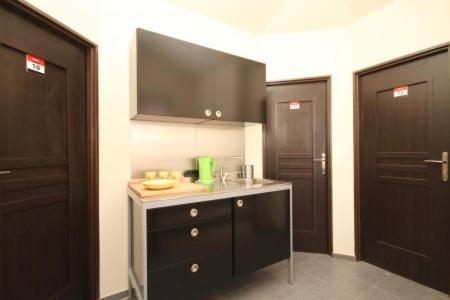 a kitchen with black doors and a counter with a sink at Ekonomiczne Pokoje Gościnne Dask Holiday in Łeba