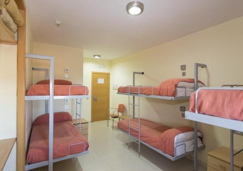 Pokój z 4 łóżkami piętrowymi z czerwoną pościelą w obiekcie Albergue Inturjoven Algeciras-Tarifa w mieście Algeciras