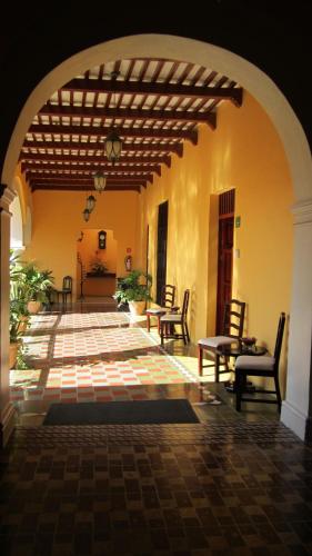 an open hallway with chairs and tables in a building at Castelmar Hotel in Campeche