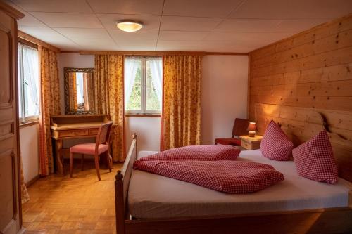 a bedroom with a bed with red pillows and a piano at Alps Hoamat in Mellau