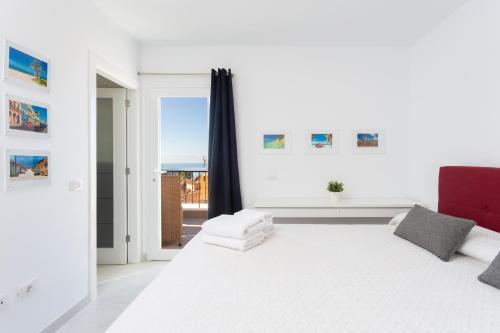 a white bedroom with a large bed and a window at Villa del Duque Chayofa in Chayofa