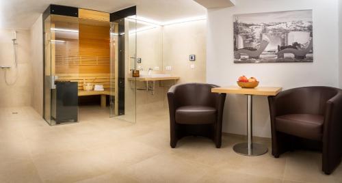 ハウス・イム・エンスタールにあるHaus Ennsegg by Schladming-Appartementsの椅子2脚、テーブル、シャワーが備わる客室です。