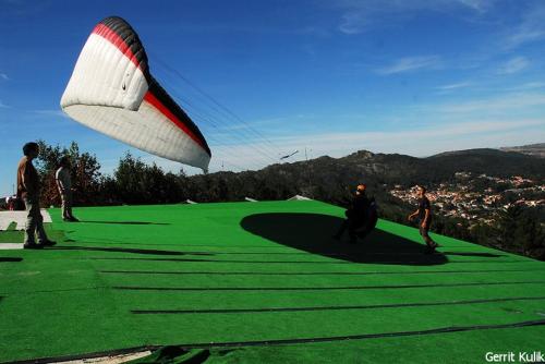 a group of people flying a kite on a green course at Casa dos Arcos in Caramulo
