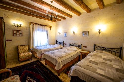 a bedroom with two beds and a chair at Sofa Hotel in Avanos