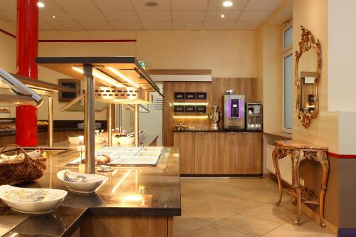 a kitchen with a counter with bowls on it at Hotel Königshof am Funkturm in Hannover