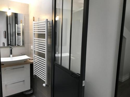 a bathroom with a glass shower and a sink at Villa le Nid in Nice