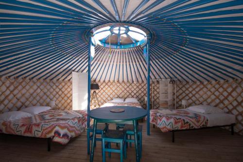 a room with two beds and a table in a yurt at Yourtes Mongoles Gavarnie in Gèdre