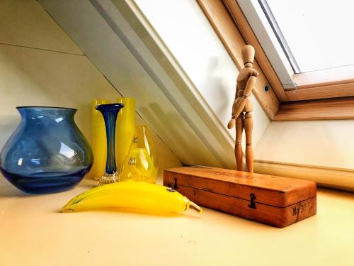 a wooden mannequin standing next to a banana and vases at B&B Zandhuizen in Zandhuizen