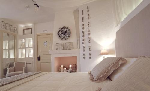 a white bedroom with a bed and a fireplace at Le Nicchie Guest House in Lucera