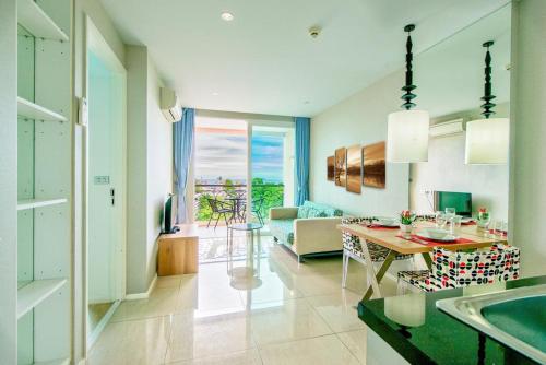 a kitchen and living room with a table and a couch at Atlantis Condo Resort jomtien in Jomtien Beach