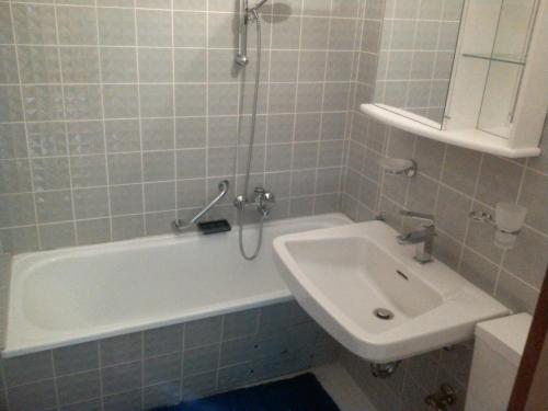 een badkamer met een wit bad en een wastafel bij 1Z. FeWo 231 barbo Schwimmbad-Sauna-Fitness in Schönwald