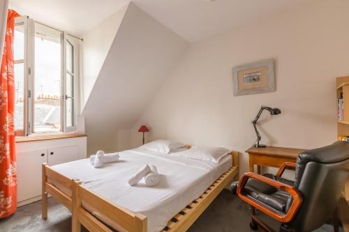 a bedroom with a bed and a desk and a chair at Veeve - Views to the Eighth in Paris