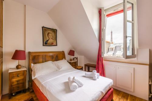 une chambre avec un lit avec des serviettes blanches dessus dans l'établissement Veeve - Views to the Eighth, à Paris