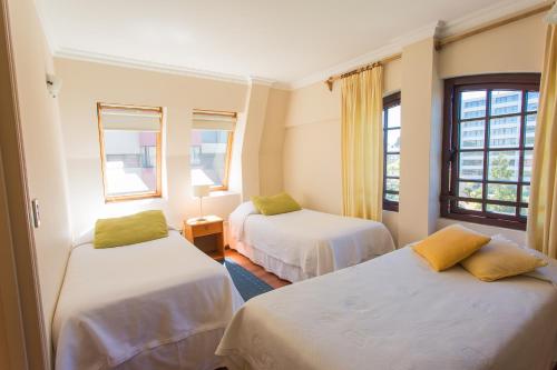 a room with two beds and two windows at Apart Hotel Montepiedra in Temuco