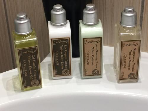 3 bouteilles de savon assises sur un lavabo dans l'établissement Appartement June, à Palasca