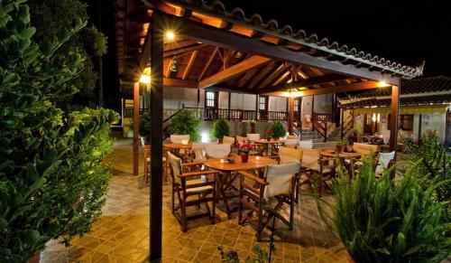 a restaurant with tables and chairs under a pergola at Studios Filippos in Skopelos Town