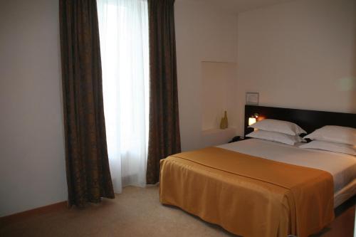 a bedroom with a bed and a large window at Hotel La Beauze in Aubusson