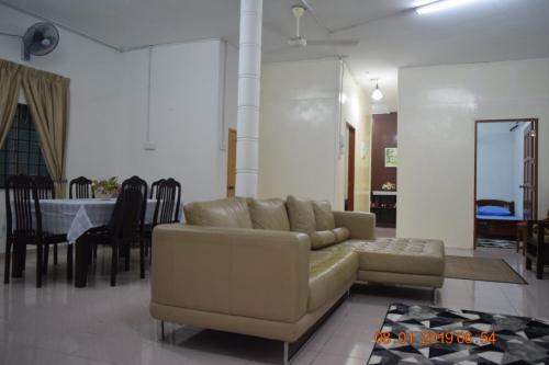 ein Wohnzimmer mit einem Sofa und einem Tisch in der Unterkunft RILEK-RILEK HOMESTAY in Jertih