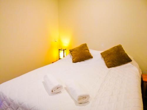 a bedroom with a white bed with two pillows at avalon residence2 in Savannakhet