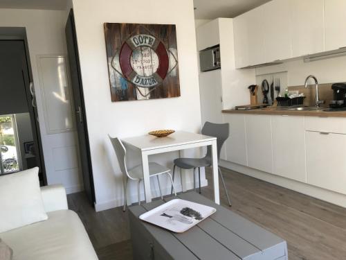 a living room with a table and a kitchen at Villa le Nid in Nice