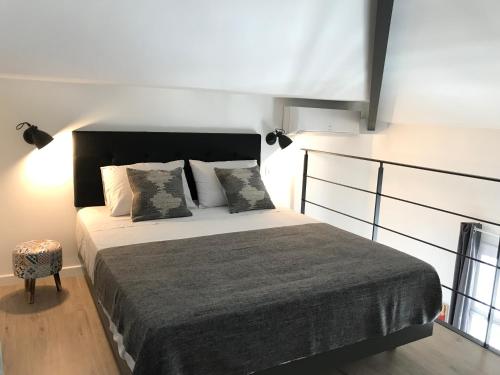 a bedroom with a bed with a black headboard and pillows at Villa le Nid in Nice