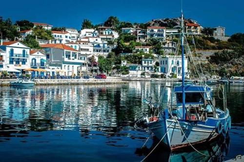 a boat is docked in a harbor with houses at Panoramma Hause, Kampos Evdilou,Ikaria in Évdhilos