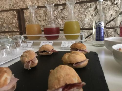 a group of sandwiches on a table with bottles of juice at Antico Borgo Chieti in Chieti