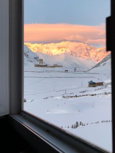 a view of a snowy mountain from a window at Guesthouse Angelina in Ushguli
