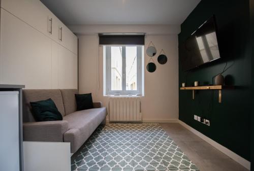 uma sala de estar com um sofá e uma janela em Studio Saint Louis - Cosy & Design em Lyon