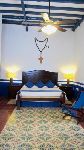 a bedroom with a bed and a cross on the wall at Castelmar Hotel in Campeche