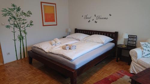 a bedroom with a bed with two slippers on it at Wohnen im Kolonialstil inklusive Tiefgarage, kontaktloser Check-in in Klagenfurt