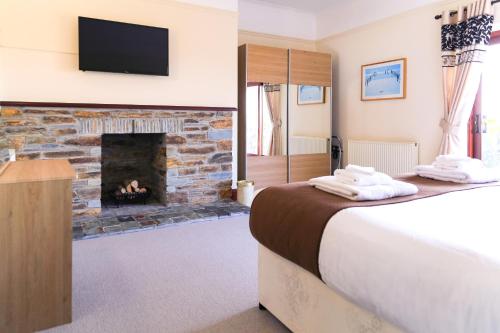 a bedroom with a bed and a fireplace at Bowood Park Hotel in Camelford