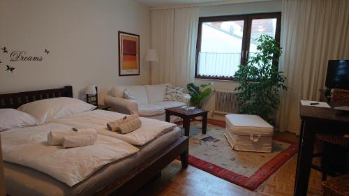 ein Wohnzimmer mit einem Bett und einem Sofa in der Unterkunft Wohnen im Kolonialstil inklusive Tiefgarage, kontaktloser Check-in in Klagenfurt am Wörthersee