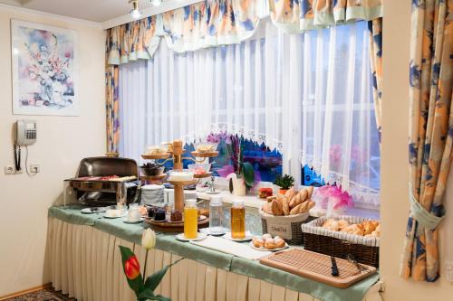 a buffet with food on a table in front of a window at Pension Zum lustigen Steirer in Bruck an der Mur