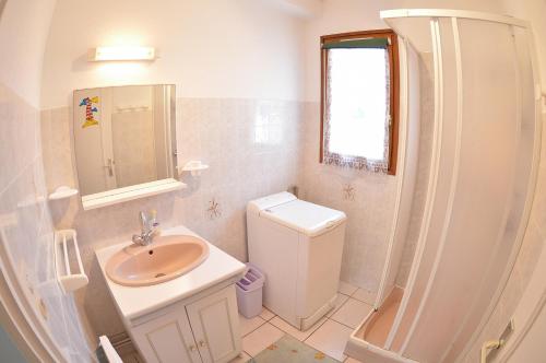 une salle de bain blanche avec un lavabo et des toilettes dans l'établissement Les Coquillages, à Mimizan-Plage