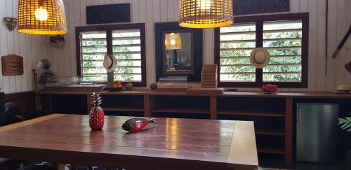 a dining room with a wooden table and two windows at la Varangue in Lacanau