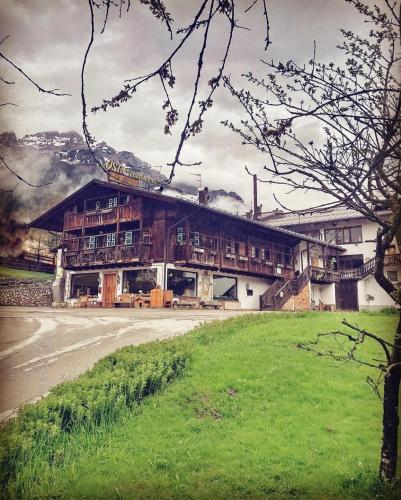 a large building in front of a green field at NONNA PINA Appartamento PUTTI in Padola
