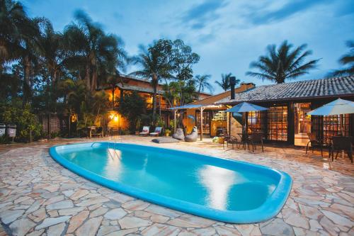 a swimming pool in a yard with a house at Pousada do Véio in Garopaba