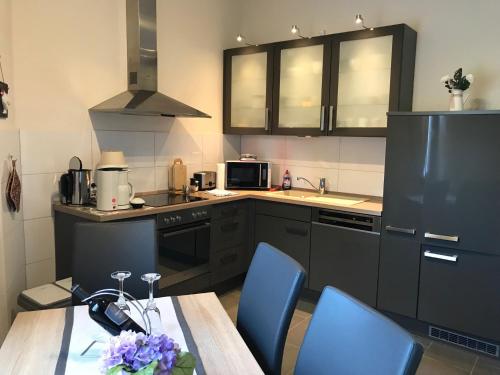 a kitchen with a table and blue chairs in it at Schlafen & Wohlfühlen in Bremerhaven