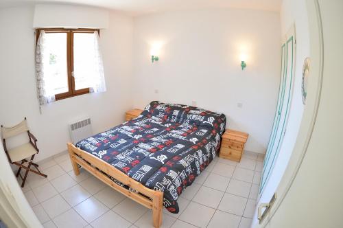 a small bedroom with a bed and a chair at Les Coquillages in Mimizan-Plage