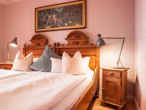 a bedroom with a bed and a painting on the wall at Das Forsthaus Hotelapartments in Bad Schandau