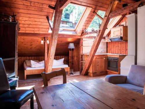a room with a wooden ceiling with a table and a bedroom at Das Forsthaus Hotelapartments in Bad Schandau